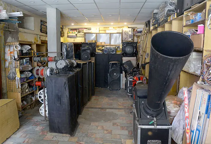 A shop displays sound system and a machine, used to shower rose petals and paper made flowers on participants of Eid Miladun Nabi procession. — Photos by Mohammad Asim