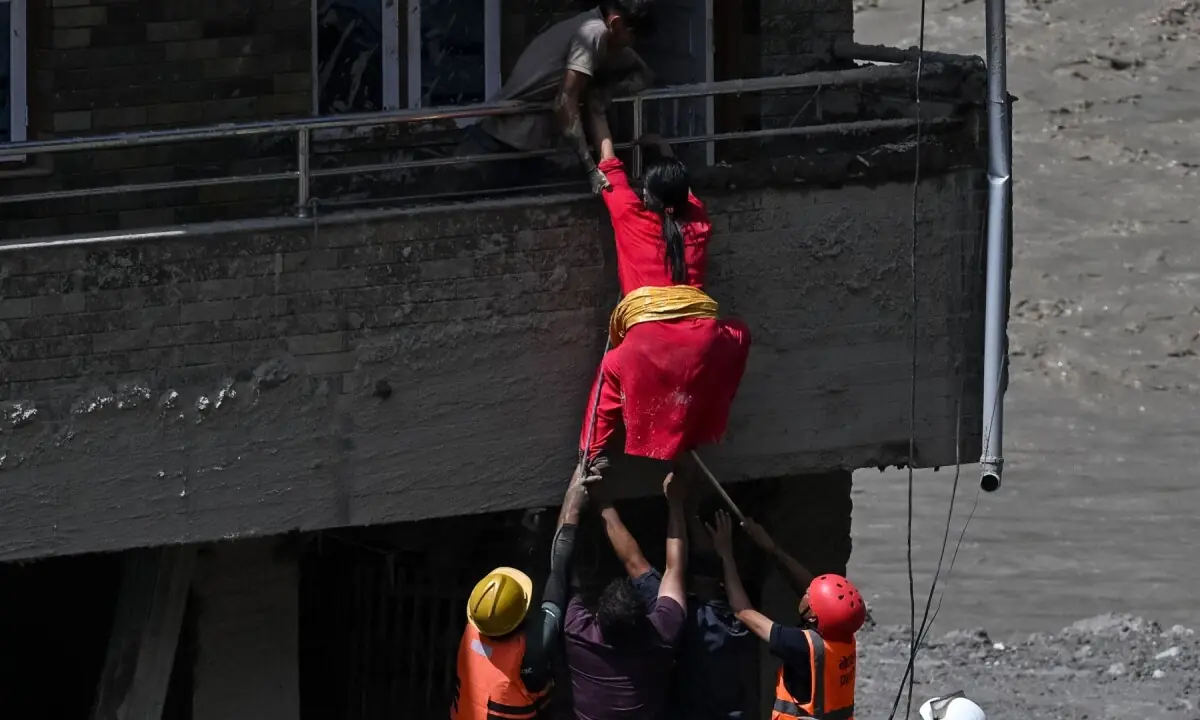 Rescue workers rescue stranded residents from a house buried in sludge after flash floods at Trishuli in Nepal&rsquo;s Nuwakot district on August 27, 2026. &mdash;AFP