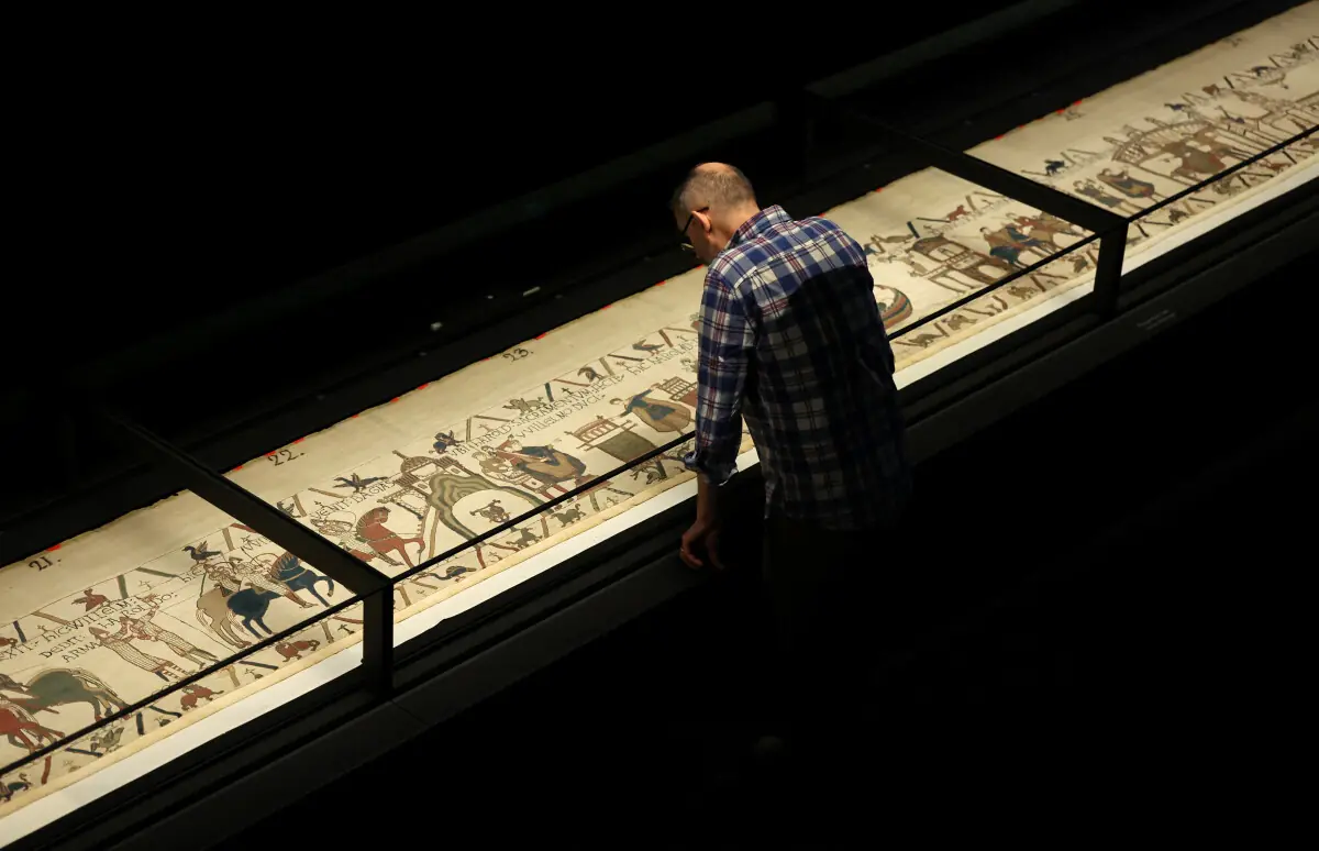  A journalist looks at a section of the Bayeux Tapestry during the press preview 