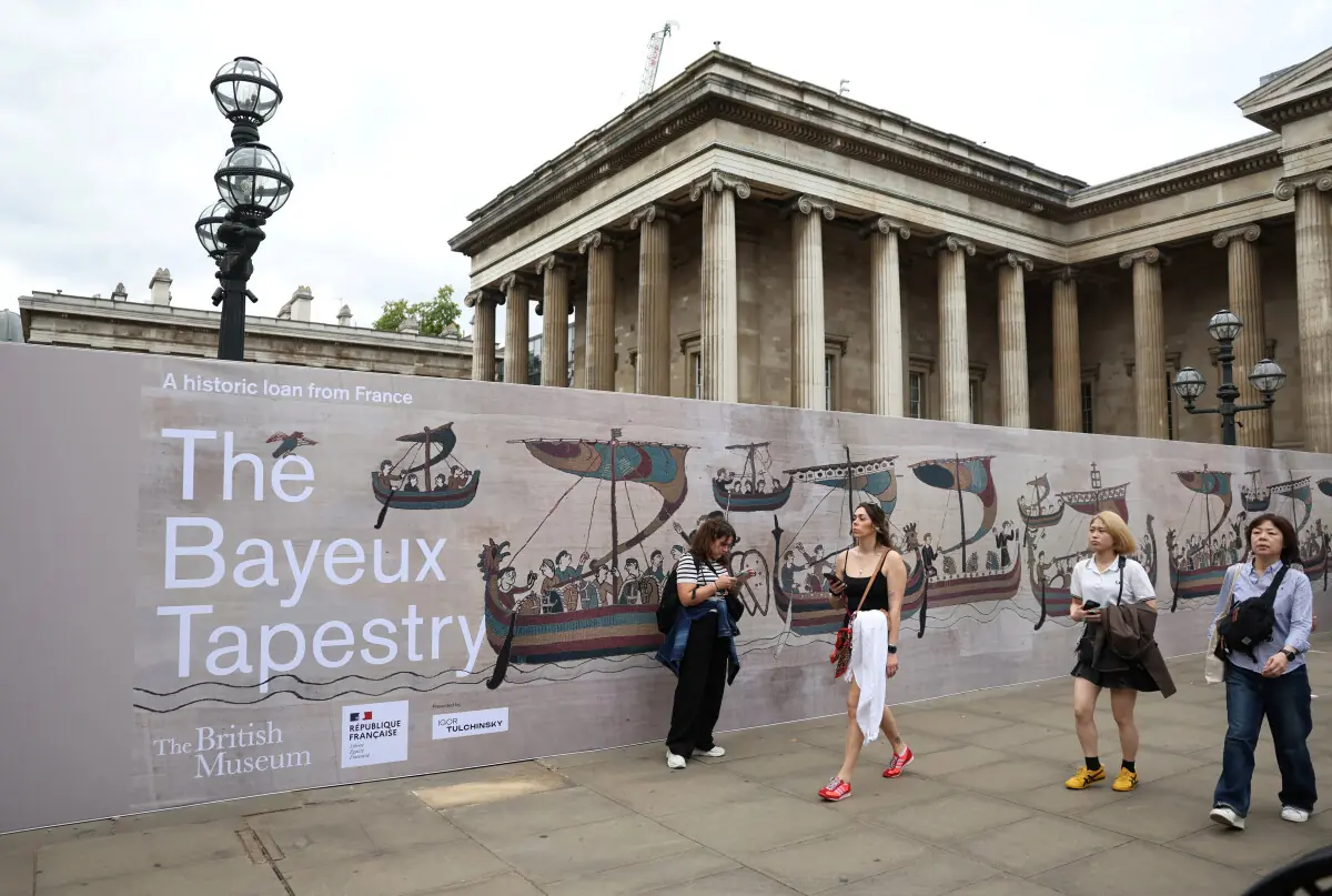  People walk past an advertisement for The Bayeux Tapestry exhibition outside the British Museum 
