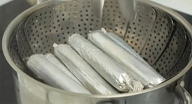 Sausages wrapped in aluminium foil being
