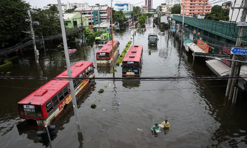 People navigate next to stranded buses in a flooded area in Bangkok, Thailand, September 28, 2026. — Reuters