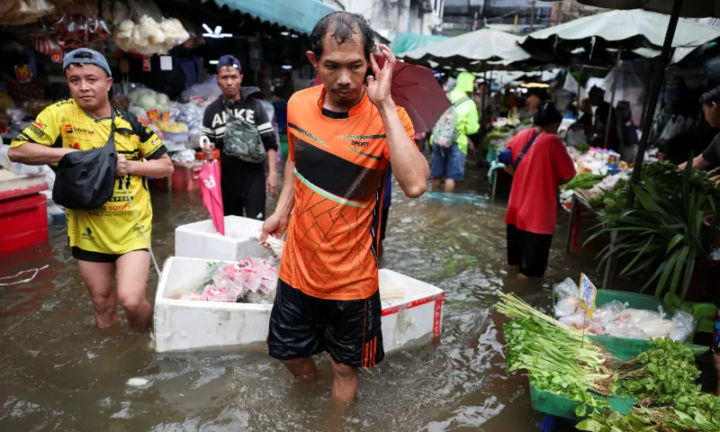 People navigate through a flooded market in Bangkok, Thailand, September 28, 2026. — Reuters