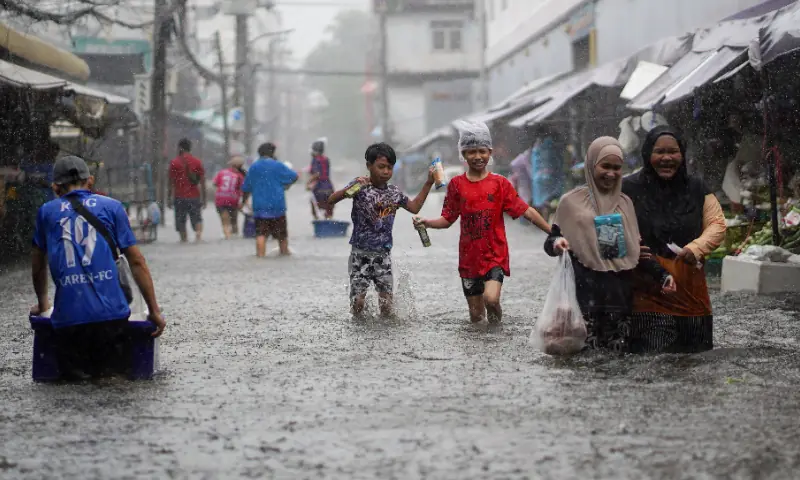 People navigate through floodwaters at a market during heavy rain, in Bangkok, Thailand, September 28, 2026. — Reuters