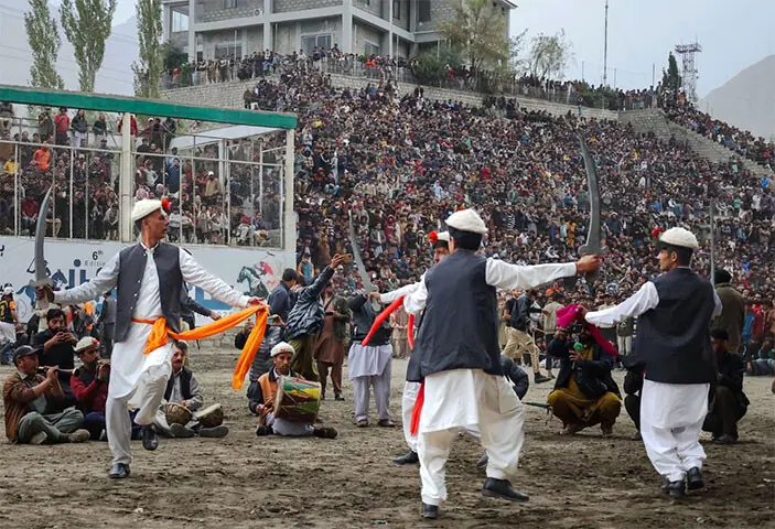 SKARDU: Local artists perform a sword dance ahead of the final match of the Ali Sher Khan Anchan Polo Tournament in Maqpoon ground.—Dawn