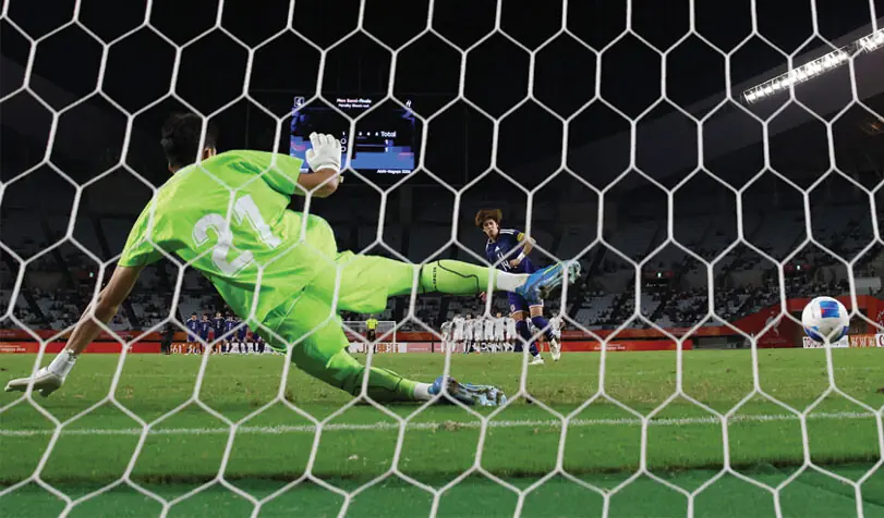OSAKA: Japan’s Yuto Ozeki scores a penalty past Uzbekistan goalkeeper Samandar Muratbaev during their Asian Games semi-final at the Nagai Stadium on Wednesday.—Reuters