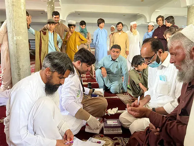 Health workers collect specimens in a village of Adenzai tehsil on Thursday. — Dawn