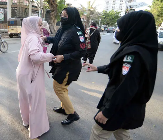 Police detain a woman supporter of the PTI on Shahrah-i-Iraq near Passport Office.—PPI