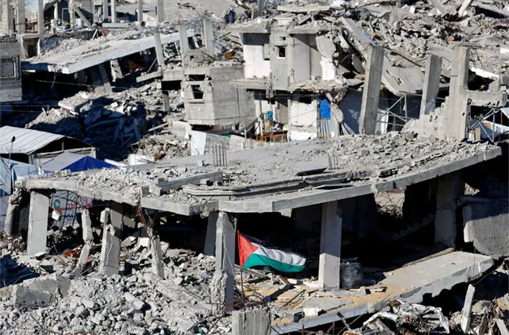  GAZA: A Palestinian flag flutters amid the ruins of residential buildings, destroyed by Israeli bombardment, as the besieged enclave marked the third anniversary of Hamas&rsquo; Oct 7 raid.&mdash;Reuters 