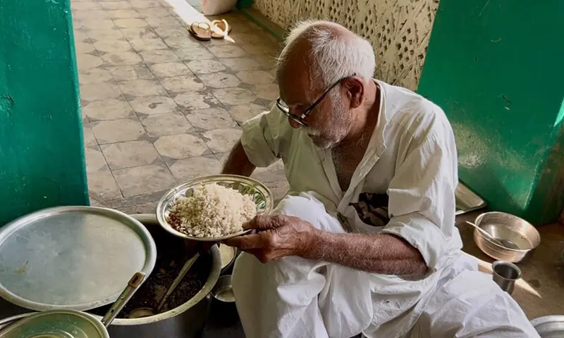 Volunteer Lachman Das prepares a plate of food for a visitor at the ashram | Photos by the writer