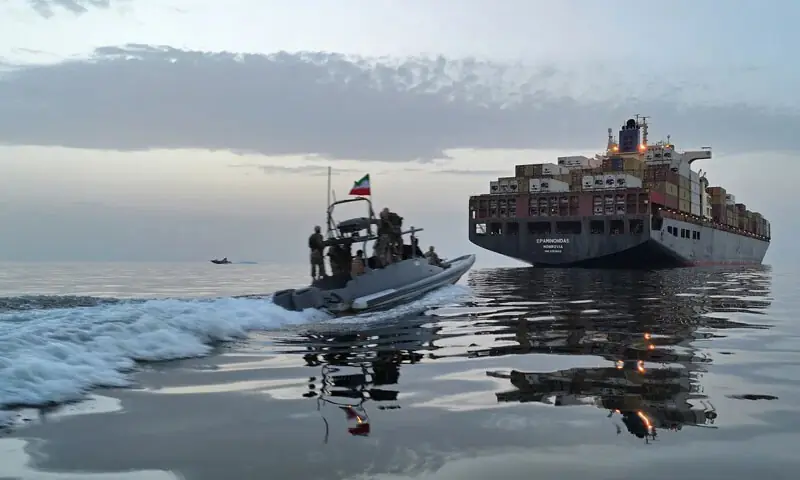  An Iranian Revolutionary Guard Corps Navy (IRGCN) speedboat approaches a cargo ship accused of violations in the Strait of Hormuz on April 21, 2026: the closure of the Strait of Hormuz and its cascading impact on the global economy exemplifies the changing nature of warfare | AFP 