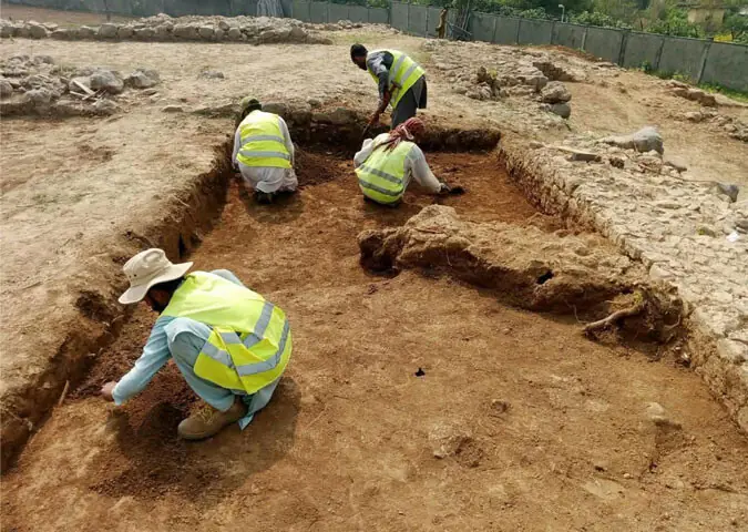 An aerial view of the Jandial site. (Right) Workers busy in excavation. — Dawn