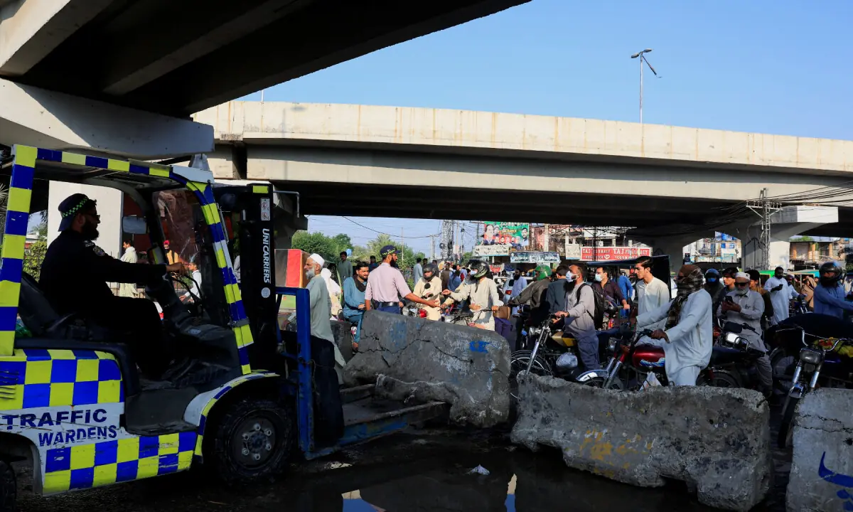 A traffic official erects cement blockades to restrict access to the Red Zone on October 12, 2026. &mdash; Reuters