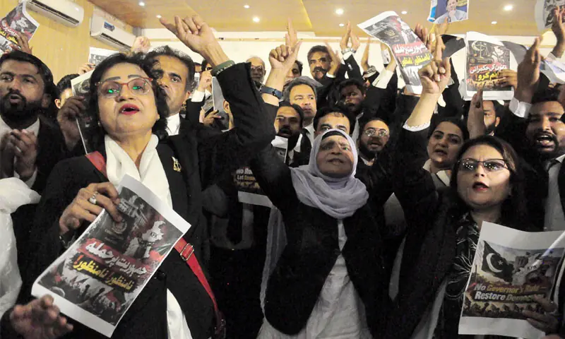 members of the Karachi Bar Association hold placards and chant slogans during a general body meeting.—AFP