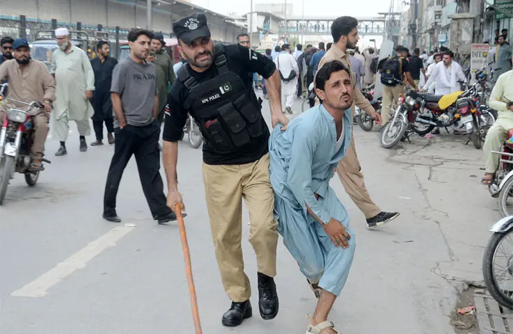 Police personnel arrest a PTI worker during a protest in the provincial capita.l— AFP/Shahbaz Butt