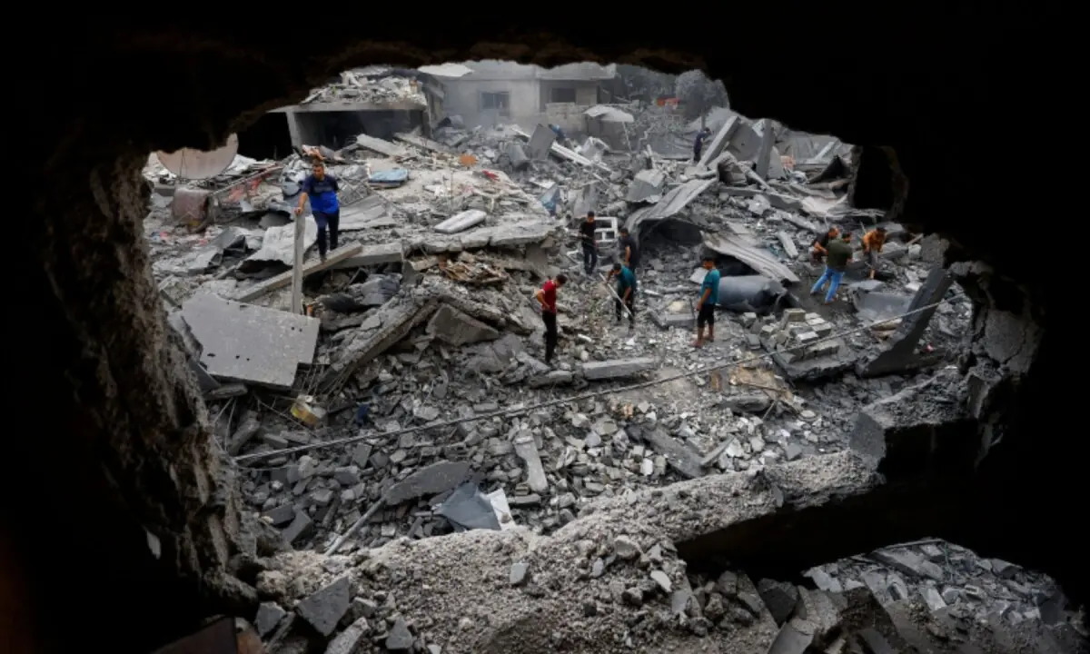 Palestinians inspect the site of a house targeted by Israeli airstrikes after the Israeli military warned residents to evacuate late on Saturday, in Al-Zawayda, central Gaza Strip on October 11, 2026. —Reuters