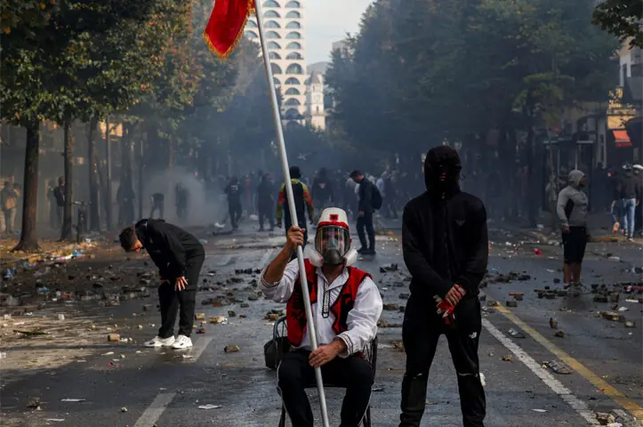 A MAN wearing an outfit resembling traditional Albanian attire sits amid debris during the protests.—Reuters