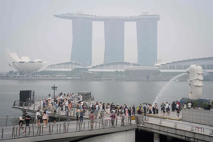 PEOPLE visit Singapore’s Merlion Park as the country remains shrouded in haze caused by fires in Indonesia.—AFP
