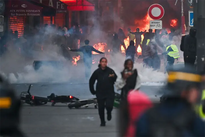 Protesters stand in front of a fire in Faubourg du Temple street as clashes erupted following a demonstration in central Paris.—AFP