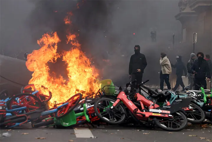 Masked protesters stand next to burning bicycles amid clashes near the Place de la Republique, in Paris, during a demonstration against the soaring cost of living.—Reuters