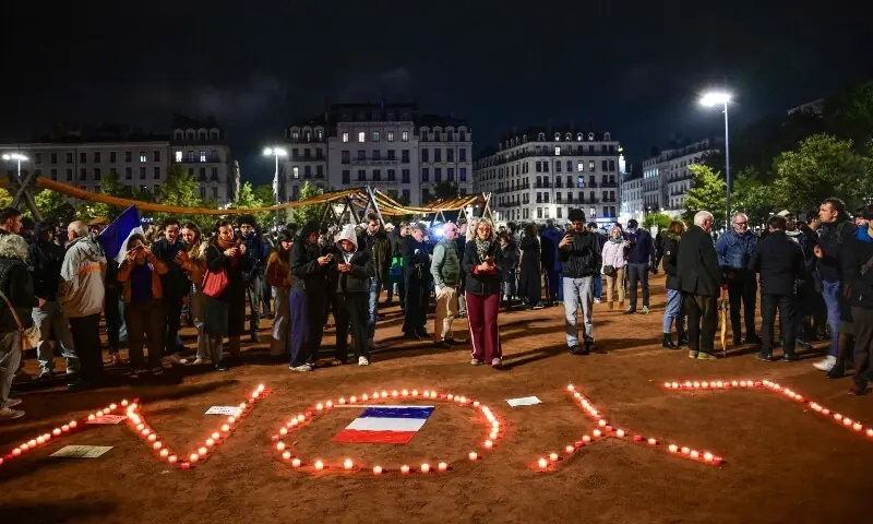 People lit candles in front of the Lyon tourist office before a partial curfew in Lyon on October 19, 2026, following weekend demonstrations over soaring prices degenerated into some of the worst street violence in recent years. —AFP