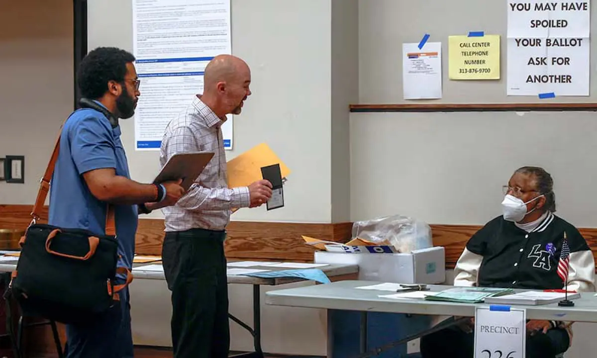 A US Department of Justice poll watcher shows his badge to a polling station worker during the Michigan primary elections, in Detroit, Michigan, the US on August 4, 2026. &mdash; Reuters/File