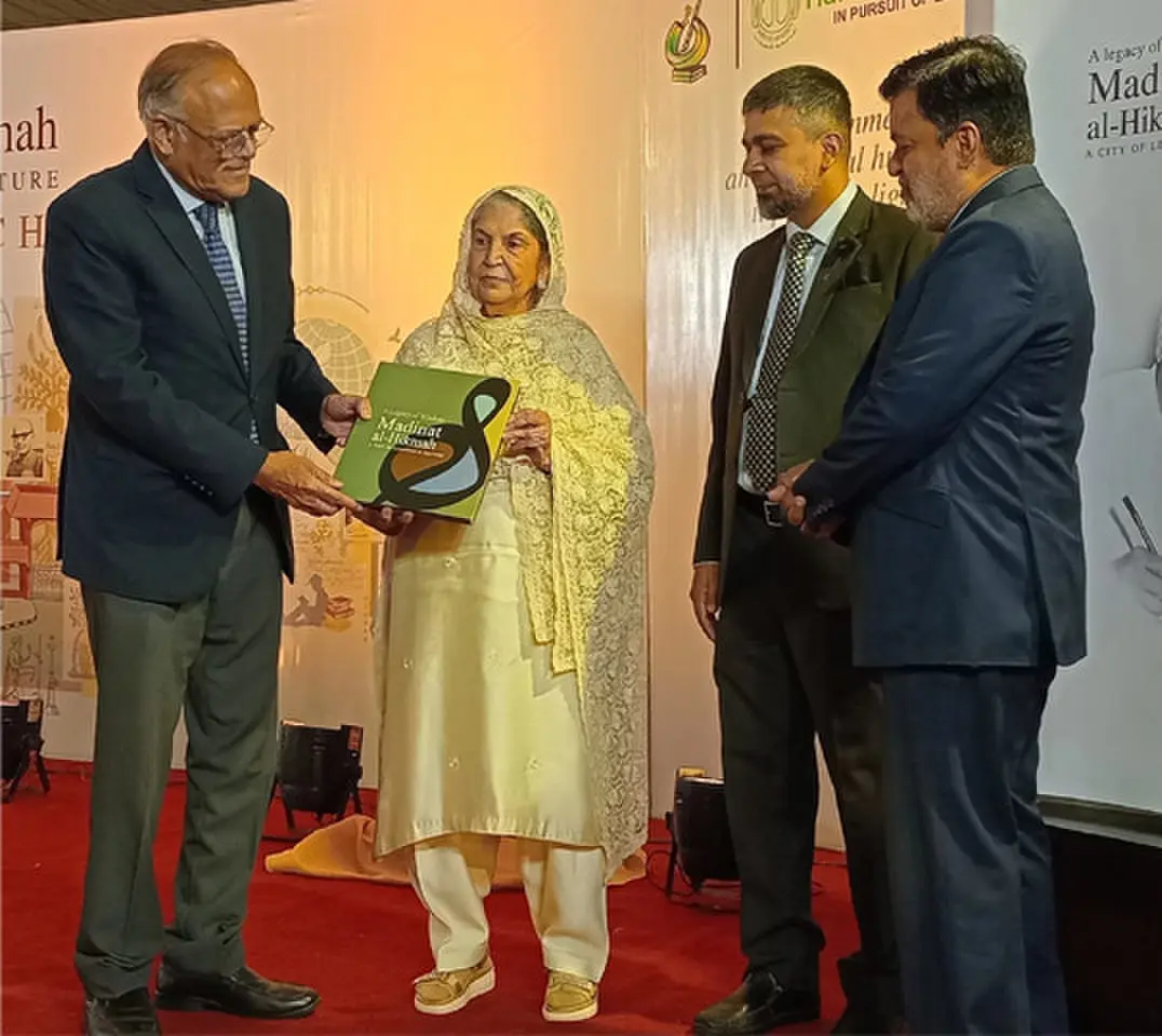   Former federal minister Javed Jabbar presents the book to Hamdard Foundation President Sadia Rashid.&mdash;Dawn  