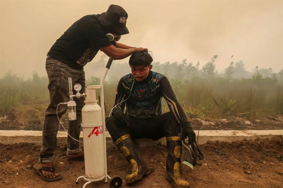   A volunteer provides mobile oxygen relief to a firefighter while battling forest  fires in Indonesia&rsquo;s Kalimantan province. Toxic haze has covered parts of Indonesia, Malaysia and Singapore for the last four weeks.&mdash;AFP  