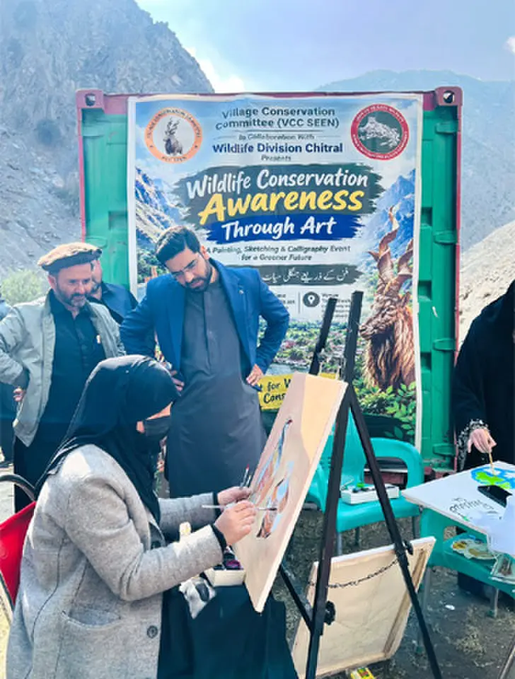    An artist paints partridges at the wildlife conservation awareness event in Chitral. &mdash; Dawn   