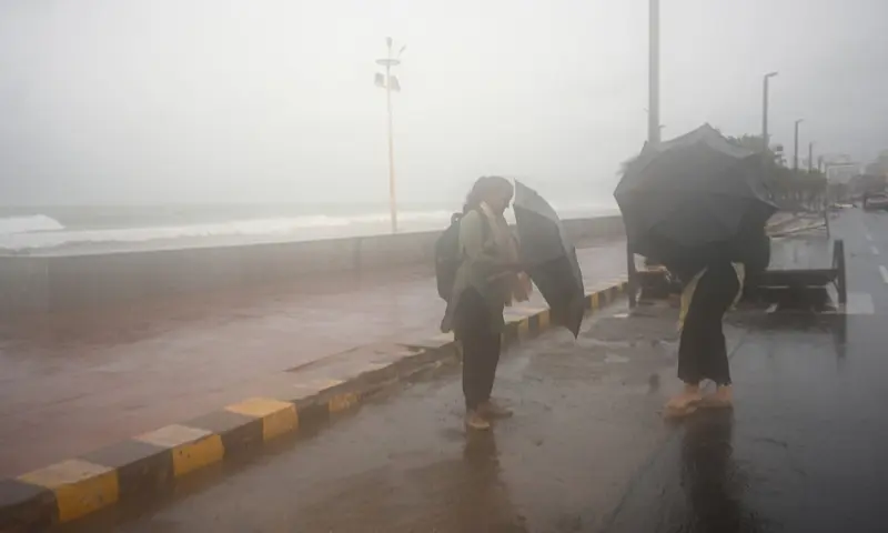 Women shield themselves under umbrellas during high tide amid rain and gusty winds as Cyclone Arnab approaches, in Visakhapatnam, Andhra Pradesh, India, on October 27, 2026. — Reuters