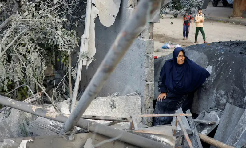 A Palestinian woman inspects the site of a house targeted by an Israeli airstrike after the Israeli military warned the residents of the house to evacuate on Thursday, in Nuseirat in the central Gaza Strip, on Oct 23, 2026. — Reuters