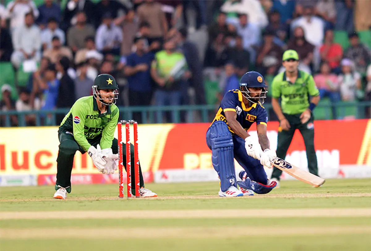LAHORE: Sri Lankan batter Kamindu Mendis plays a shot as Pakistan wicket-keeper Saad Baig looks on during the One-day International tri-series match at the Gaddafi Stadium on Tuesday.—M. Arif/White Star