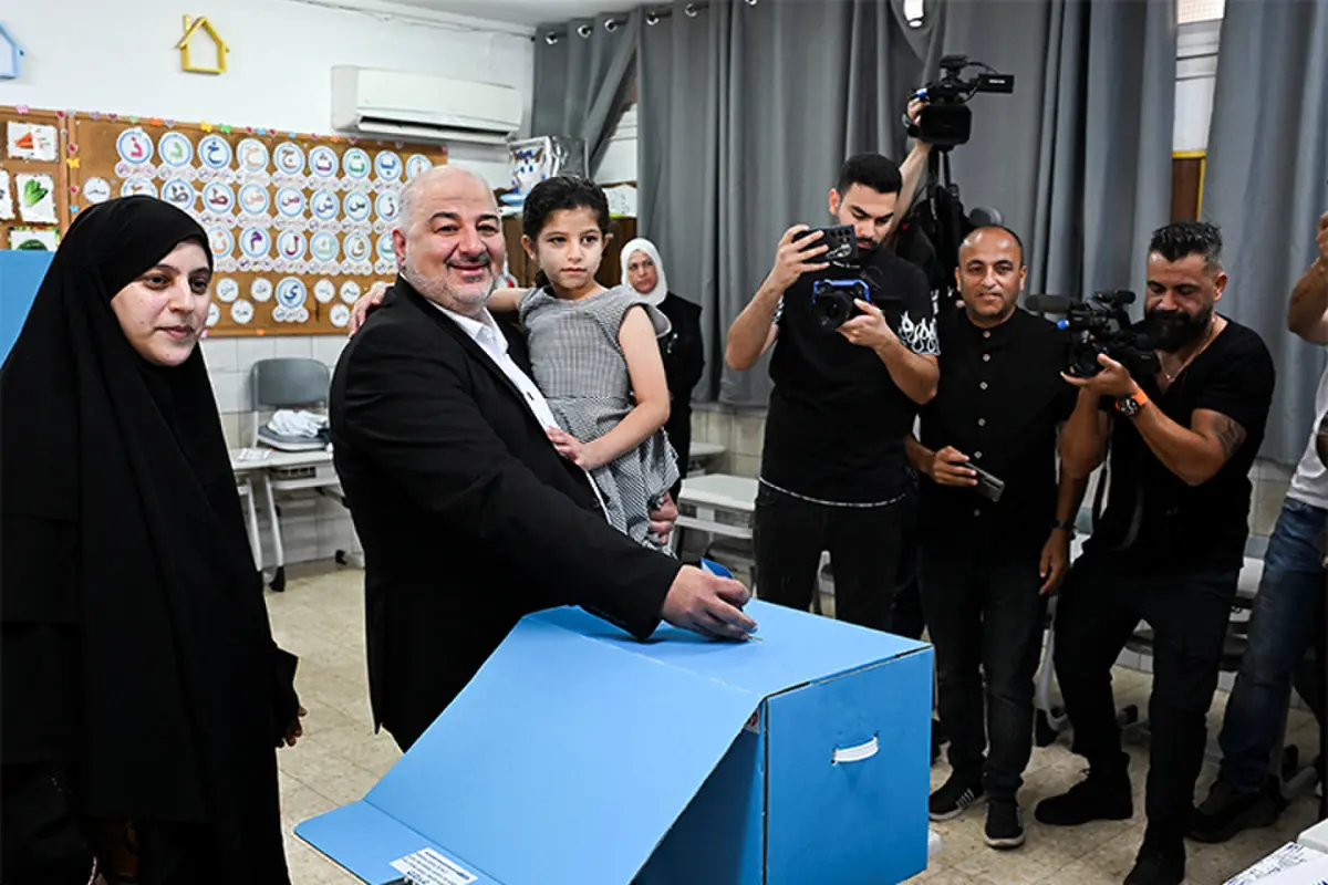 Ra’am party leader Mansour Abbas holds his daughter at a polling station in Maghar, Israel.—Reuters