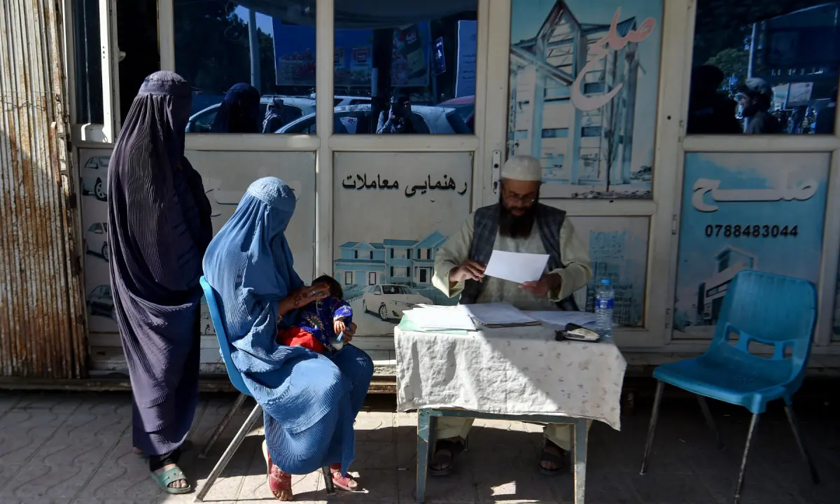 This photograph taken on October 20, 2026 shows burqa-clad women waiting at a petition writer’s desk in Sheberghan in Afghanistan’s Jawzjan province. — AFP