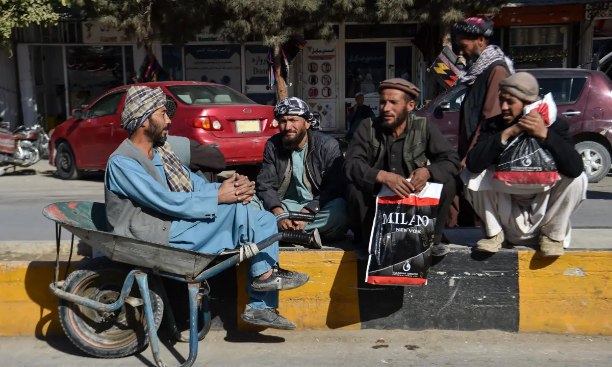 This photograph taken on October 20, 2026 shows daily wage labourers sitting along a road at Sheberghan in Afghanistan’s Jawzjan province. — AFP