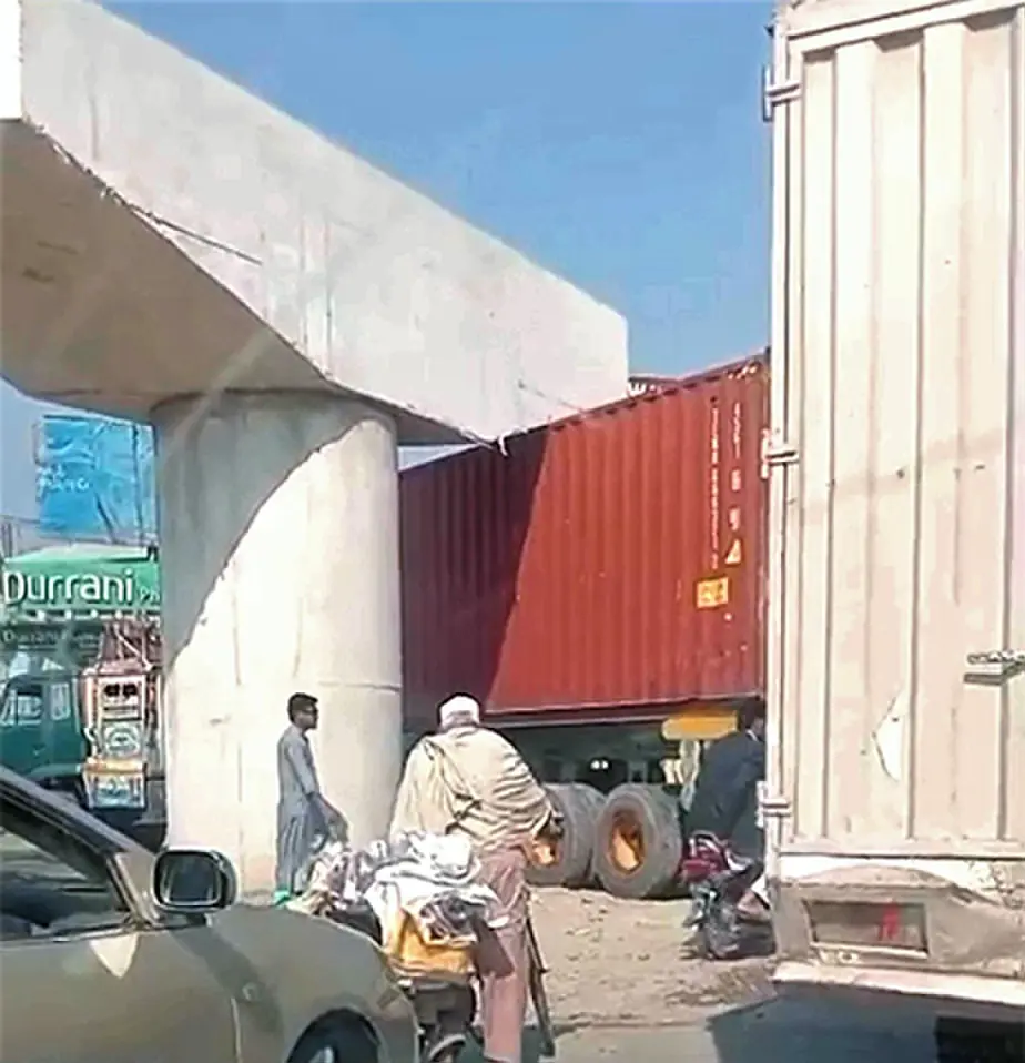 A container truck stuck under a flyover pier on Mardan Road, Charsadda. — Dawn
