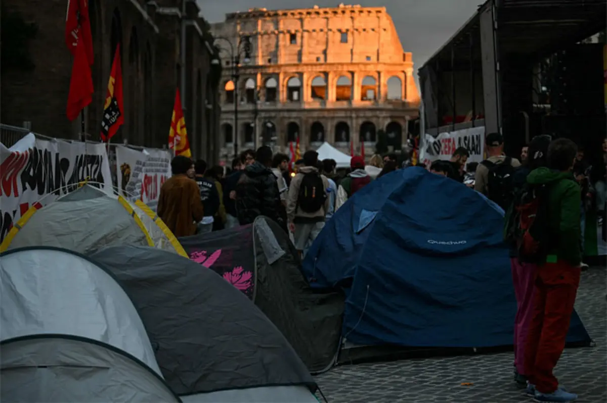 Protesters block a street with tents in front of the Colosseum during a demonstration in Rome.—AFP