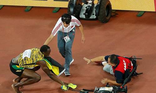 Cameraman takes down Usain Bolt after 200m win Cameraman takes down Usain Bolt after 200m win