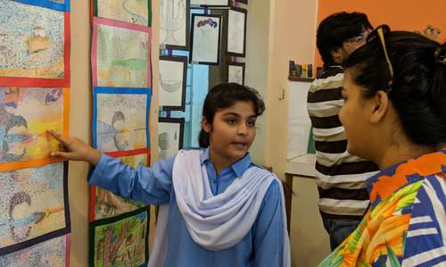 A student explaining the artwork to visitors.