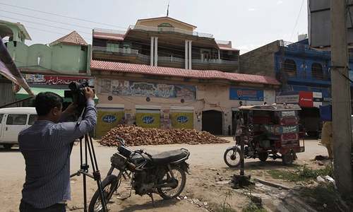 A member of the media films the house of Sana Cheema in the neighbourhood of Mangowal, near Gujrat. — AP