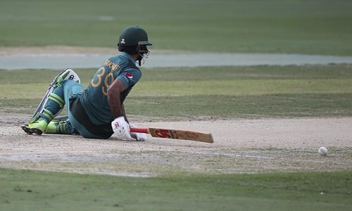 Fakhar Zaman falls on the ground after he was dismissed by India's Kuldeep Yadav. — AP