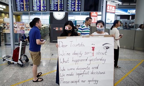 Flights restart at Hong Kong airport as protesters apologise