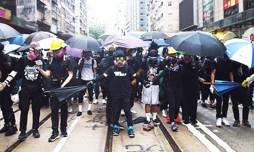 Hong Kong lashed by fresh violence as thousands defy mask ban