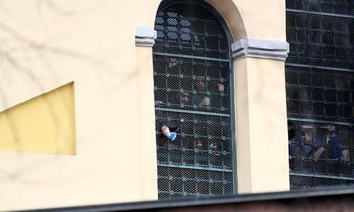 Prison inmates gather by a barred window at San Vittore Prison as part of a revolt after family visits were suspended due to fears over coronavirus contagion in Milan on March 9. — Reuters