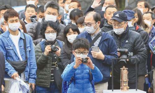 Thousands flock to see Olympic flame despite virus fears