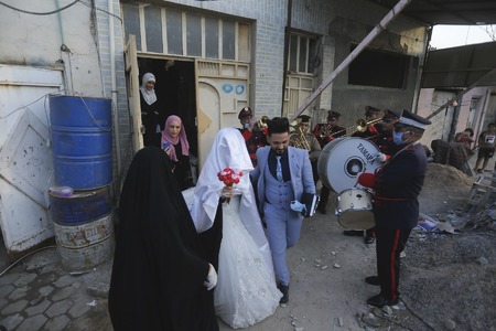 In pictures: Iraqi couple gets police help to wed amid curfew