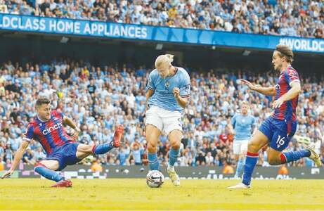 MANCHESTER: Manchester City’s Erling Braut Haaland shoots to score and complete his hat-trick during the Premier League match against Crystal Palace at the Etihad Stadium on Saturday.—Reuters