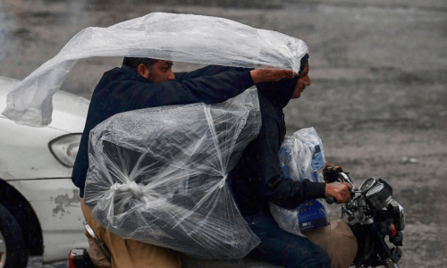Thundering clouds, intermittent rain keep people indoors in Karachi