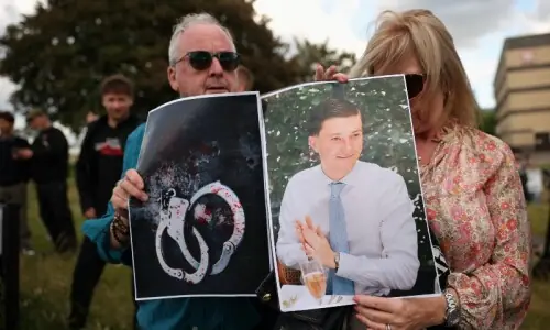 Dying student in handcuff image stirs outrage in Britain
