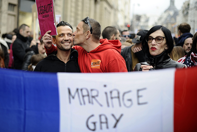 A picture taken on December 16, 2012 in Paris shows a man kissing his companion during a demonstration for the legalisation of gay marriage and LGBT (lesbian, gay, bisexual, and transgender) parenting. France became the 14th country to legalise same-sex marriage on May 18, 2013 after President Francois Hollande signed the measure into law following months of bitter political debate.  Hollande acted a day after the Constitutional Council threw out a legal challenge by the right-wing opposition, which had been the la